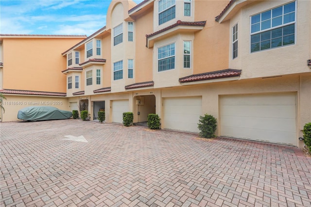 4034 N Ocean Dr, Hollywood, FL 33019 - view of front of house featuring stucco siding, driveway, an attached garage, and a tiled roof