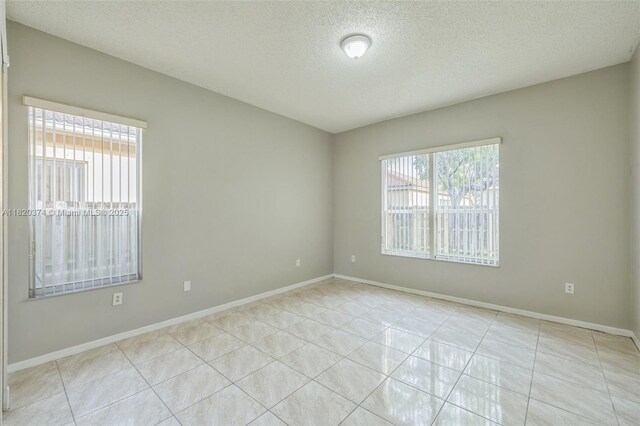 1951 NE 3rd Ct, Homestead, FL 33033 - unfurnished room featuring a textured ceiling and tile patterned flooring