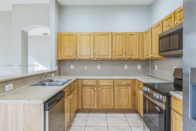 1951 NE 3rd Ct, Homestead, FL 33033 - kitchen with stainless steel appliances, arched walkways, light countertops, and tasteful backsplash