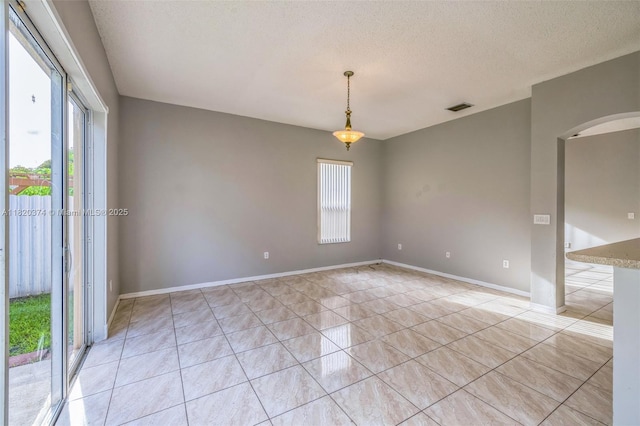 1951 NE 3rd Ct, Homestead, FL 33033 - unfurnished room featuring plenty of natural light, light tile patterned floors, arched walkways, and a textured ceiling