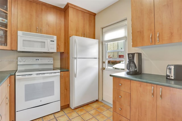4311 NW 16th St Unit B103, Lauderhill, FL 33313 - kitchen featuring white appliances, glass insert cabinets, light tile patterned flooring, dark countertops, and brown cabinets