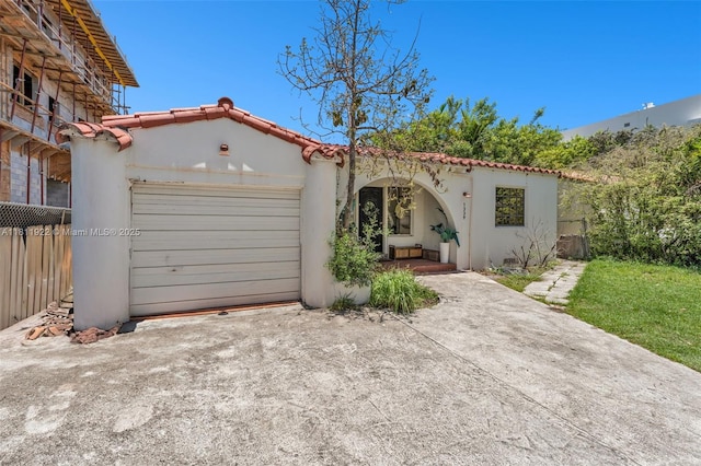 1339 14th Ter, Miami Beach, FL 33139 - mediterranean / spanish-style house featuring driveway, an attached garage, stucco siding, and a tiled roof