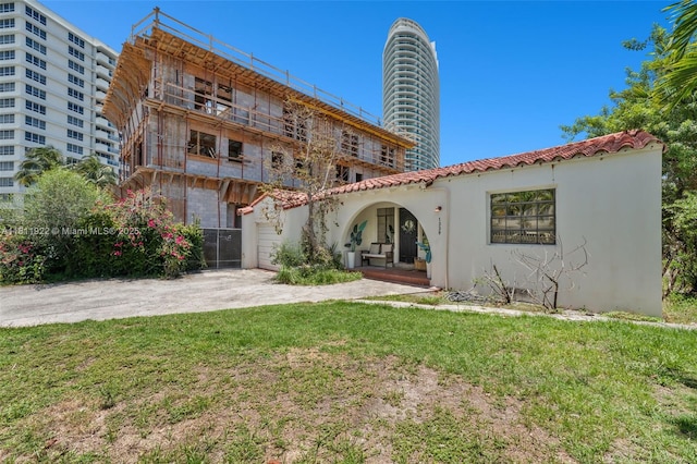 1339 14th Ter, Miami Beach, FL 33139 - back of house featuring a tiled roof, a yard, stucco siding, concrete driveway, and a garage
