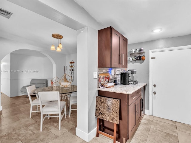 17320 SW 117th Ave, Miami, FL 33177 - kitchen featuring arched walkways, backsplash, recessed lighting, light stone counters, and pendant lighting