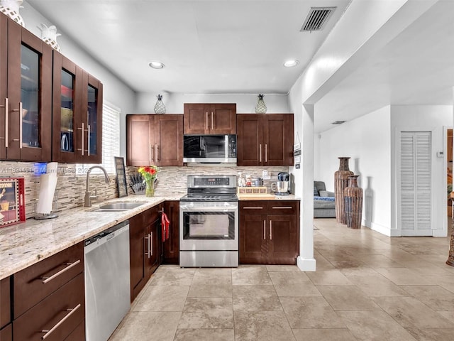17320 SW 117th Ave, Miami, FL 33177 - kitchen featuring appliances with stainless steel finishes, tasteful backsplash, light stone counters, recessed lighting, and glass insert cabinets