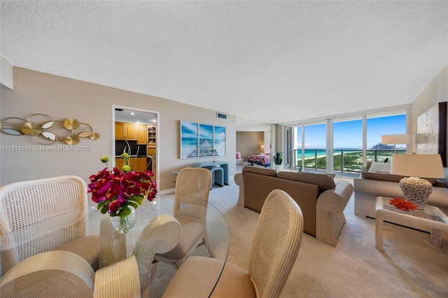 100 Bayview Dr Unit 1922, Sunny Isles Beach, FL 33160 - dining room featuring light carpet, a textured ceiling, expansive windows, and a water view
