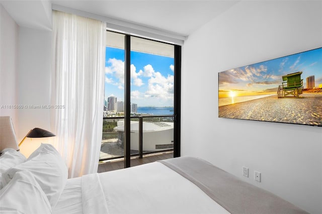 398 NE 5th St Unit 1809, Miami, FL 33132 - bedroom featuring a wall of windows, access to exterior, multiple windows, and wood finished floors