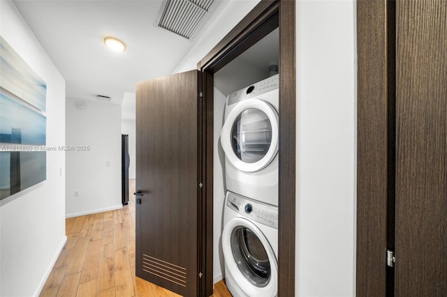 398 NE 5th St Unit 1809, Miami, FL 33132 - washroom featuring stacked washing machine and dryer and light wood-style flooring