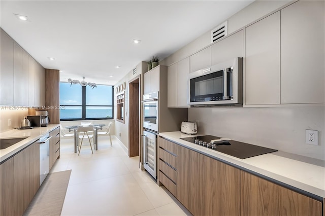 3 Grove Isle Dr Unit C602, Miami, FL 33133 - kitchen with stainless steel appliances, modern cabinets, light countertops, a chandelier, and recessed lighting