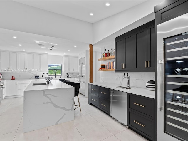4531 SW 15th St, Miami, FL 33134 - kitchen with wine cooler, built in refrigerator, dark cabinetry, white cabinets, and recessed lighting