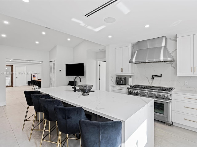 4531 SW 15th St, Miami, FL 33134 - kitchen with wall chimney range hood, stainless steel range with gas cooktop, white cabinetry, light stone countertops, and recessed lighting