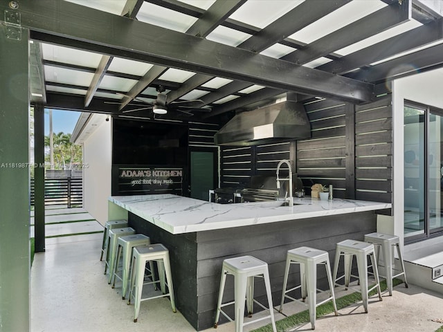 4531 SW 15th St, Miami, FL 33134 - kitchen with range hood, a ceiling fan, stone countertops, and a kitchen bar