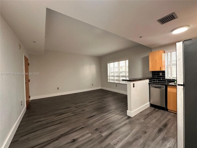 1542 Drexel Ave Unit 107, Miami Beach, FL 33139 - kitchen featuring stainless steel appliances, a peninsula, dark countertops, dark wood-type flooring, and open floor plan