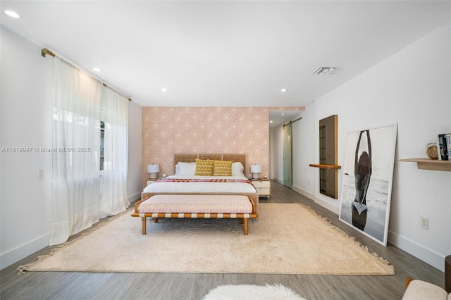 7755 Noremac Ave, Miami Beach, FL 33141 - bedroom with wallpapered walls, an accent wall, wood finished floors, and recessed lighting