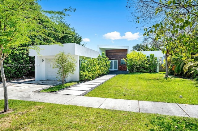7755 Noremac Ave, Miami Beach, FL 33141 - contemporary house with a front yard, a garage, driveway, and stucco siding