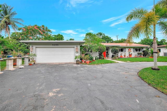 6285 Pine Ter, Plantation, FL 33317 - ranch-style home with asphalt driveway, stucco siding, a garage, and a front yard