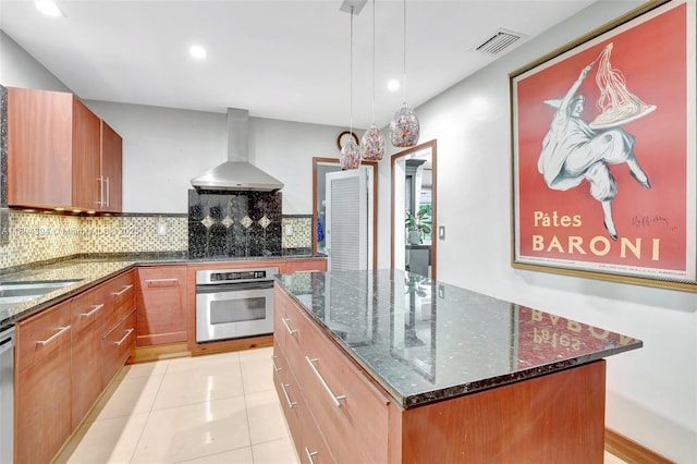 6285 Pine Ter, Plantation, FL 33317 - kitchen featuring wall chimney exhaust hood, stainless steel appliances, decorative backsplash, a kitchen island, and dark stone counters