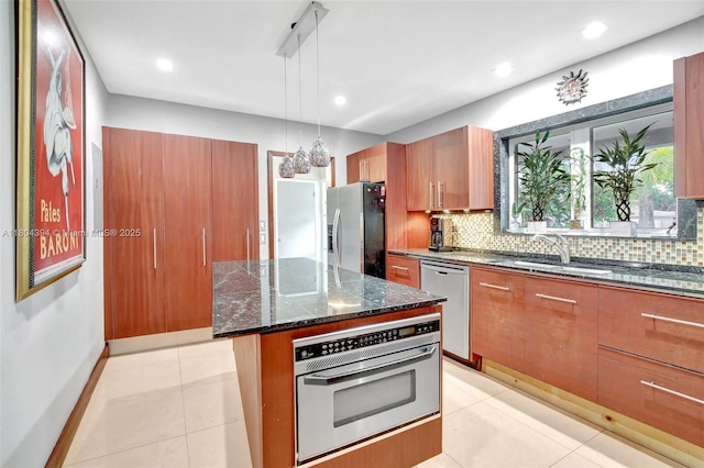 6285 Pine Ter, Plantation, FL 33317 - kitchen with appliances with stainless steel finishes, dark stone counters, tasteful backsplash, hanging light fixtures, and a kitchen island