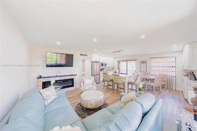 126 Piedmont C 126, Delray Beach, FL 33484 - living area featuring light wood finished floors, a glass covered fireplace, and recessed lighting