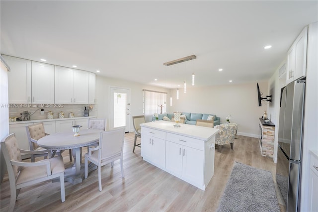 126 Piedmont C 126, Delray Beach, FL 33484 - kitchen with freestanding refrigerator, white cabinets, decorative backsplash, light wood-type flooring, and open floor plan