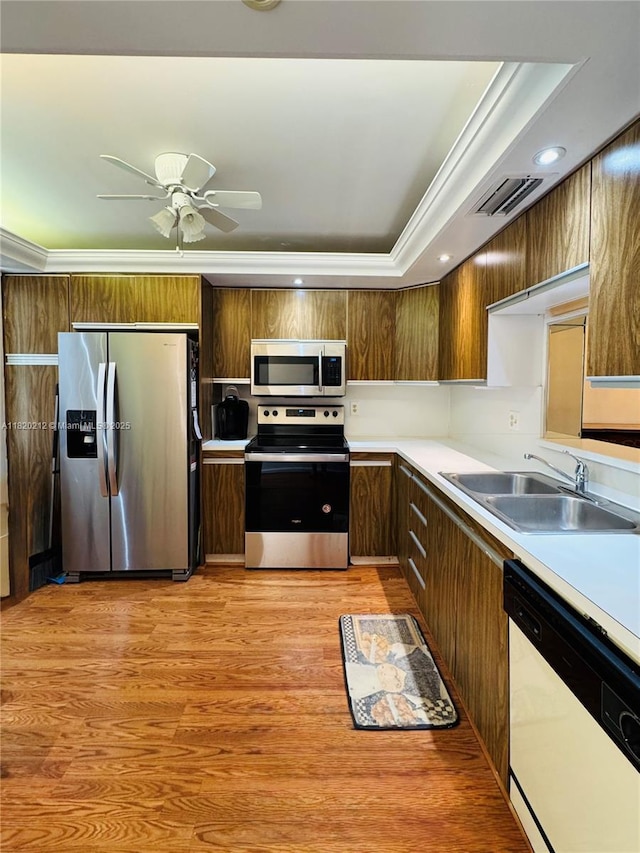 2304 Lucaya Ln Unit J1, Coconut Creek, FL 33066 - kitchen featuring stainless steel appliances, light wood finished floors, light countertops, a ceiling fan, and a raised ceiling