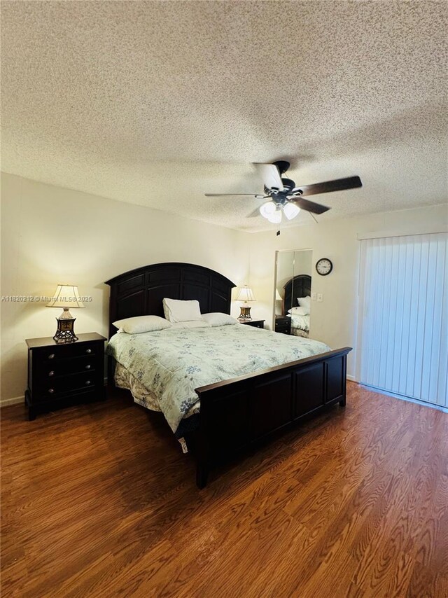 2304 Lucaya Ln Unit J1, Coconut Creek, FL 33066 - bedroom featuring dark wood finished floors, a textured ceiling, and a ceiling fan