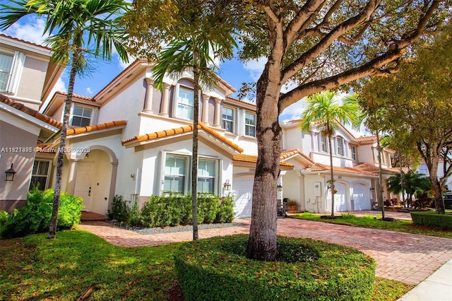 10857 NW 84th St, Doral, FL 33178 - view of front of home featuring stucco siding, a tile roof, curved driveway, and an attached garage