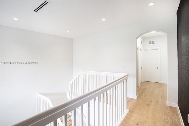 10857 NW 84th St, Doral, FL 33178 - hall featuring arched walkways, light wood-type flooring, recessed lighting, and an upstairs landing