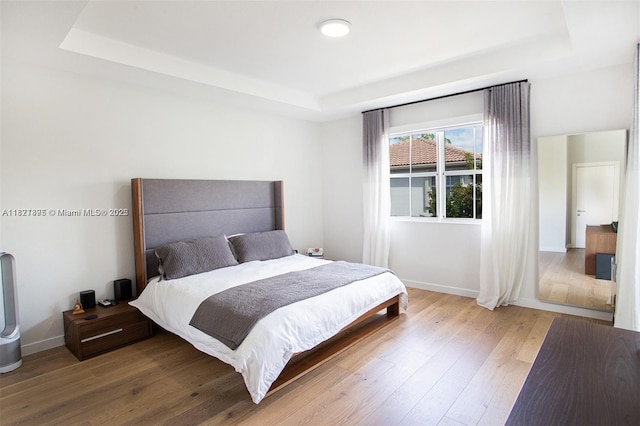 10857 NW 84th St, Doral, FL 33178 - bedroom featuring a tray ceiling and hardwood / wood-style flooring