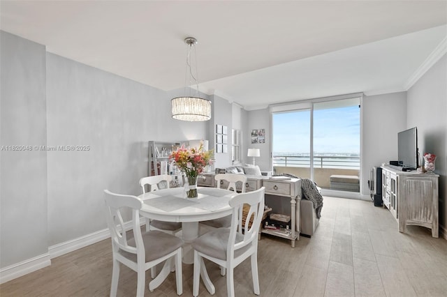 888 Brickell Key Dr Unit 1006, Miami, FL 33131 - dining room featuring crown molding, light wood-type flooring, and a chandelier
