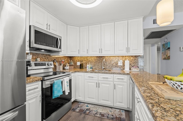 3021 Ellesmere B 3021, Deerfield Beach, FL 33442 - kitchen featuring stainless steel appliances, wood finished floors, white cabinetry, and decorative backsplash