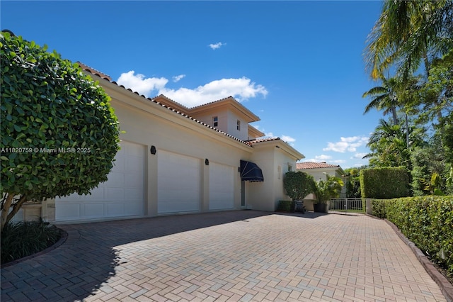 180 Solano Prado, Coral Gables, FL 33156 - view of property exterior featuring a tiled roof, decorative driveway, a garage, stucco siding, and a gate