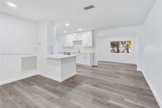 6675 NW 15th St, Margate, FL 33063 - kitchen featuring light countertops, white cabinetry, recessed lighting, light wood-style floors, and a peninsula
