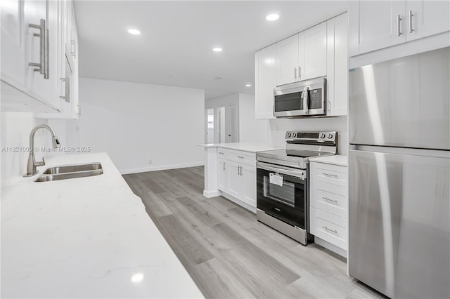 6675 NW 15th St, Margate, FL 33063 - kitchen featuring appliances with stainless steel finishes, light wood-type flooring, white cabinets, recessed lighting, and light stone counters