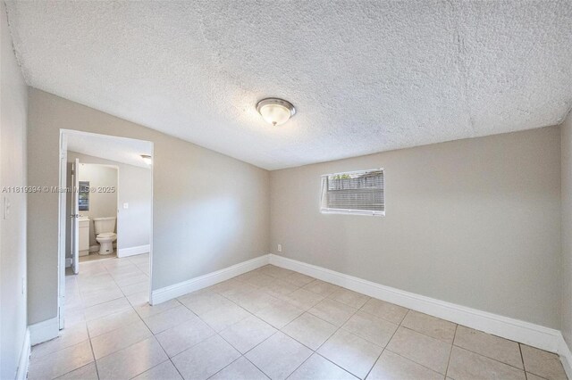 5736 Simms St, Hollywood, FL 33021 - empty room featuring light tile patterned floors, a textured ceiling, and lofted ceiling