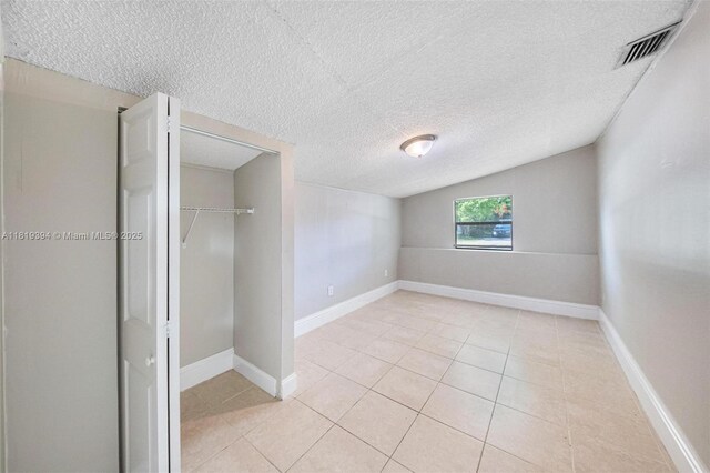 5736 Simms St, Hollywood, FL 33021 - unfurnished bedroom with light tile patterned flooring, a textured ceiling, a closet, and lofted ceiling