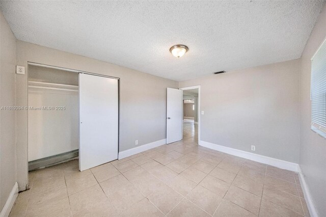 5736 Simms St, Hollywood, FL 33021 - unfurnished bedroom with a textured ceiling, light tile patterned floors, and a closet