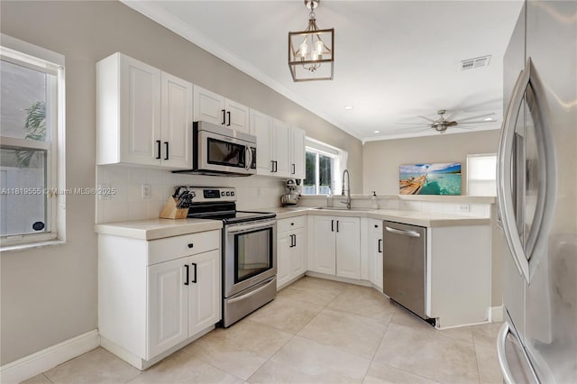 15201 SW 46th Ct, Miramar, FL 33027 - kitchen with stainless steel appliances, decorative backsplash, white cabinets, light countertops, and light tile patterned floors