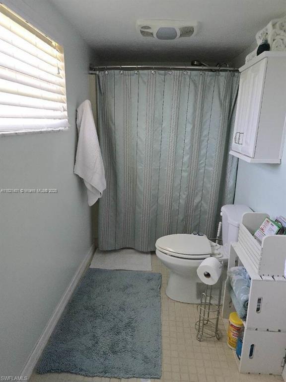 13001 Shetland Ln, Fort Myers, FL 33912 - bathroom with tile patterned floors and a shower with curtain
