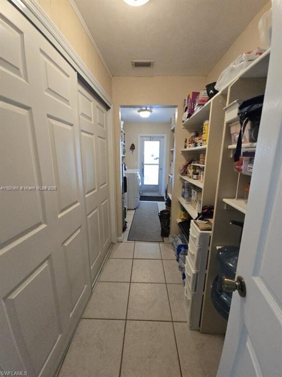 13001 Shetland Ln, Fort Myers, FL 33912 - corridor featuring separate washer and dryer and light tile patterned floors