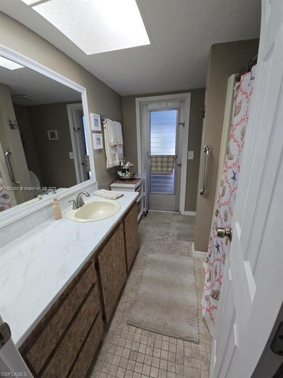 13001 Shetland Ln, Fort Myers, FL 33912 - full bathroom featuring vanity, tile patterned flooring, and a skylight