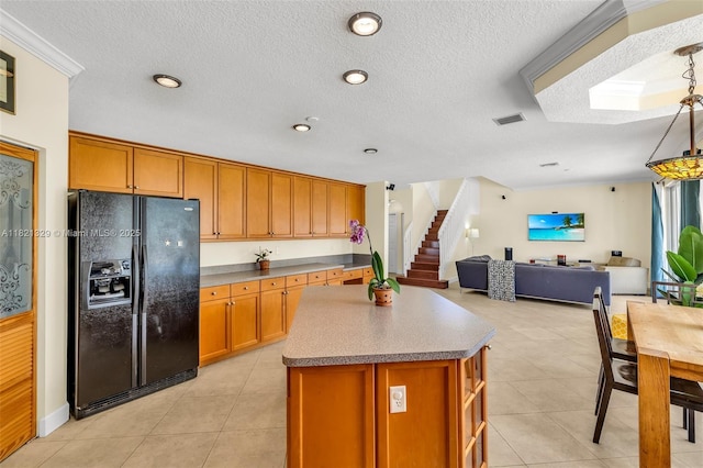 15631 SW 53rd St, Miramar, FL 33027 - kitchen with black fridge, a kitchen island, open floor plan, brown cabinets, and a textured ceiling