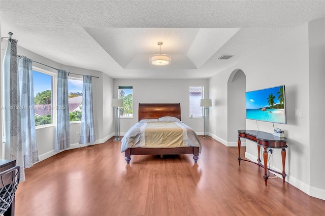 15631 SW 53rd St, Miramar, FL 33027 - bedroom featuring arched walkways, wood finished floors, a tray ceiling, and a textured ceiling