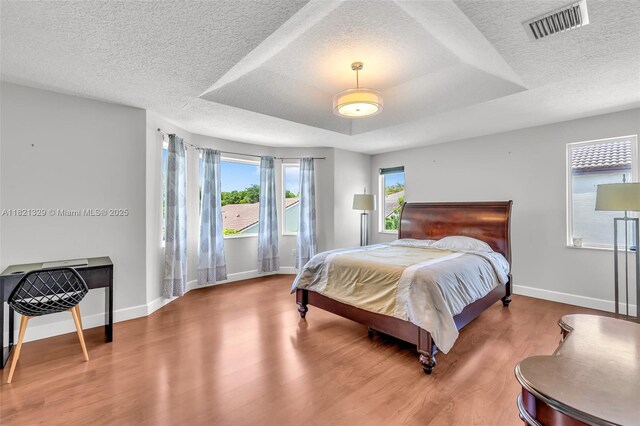 15631 SW 53rd St, Miramar, FL 33027 - bedroom featuring wood finished floors, a textured ceiling, and a raised ceiling