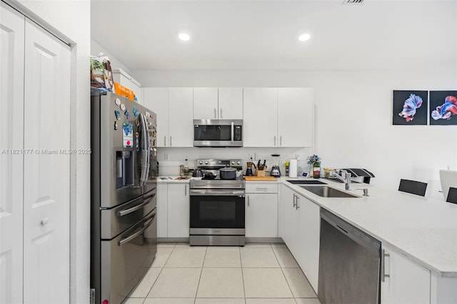 23404 SW 131st Ave, Homestead, FL 33032 - kitchen with appliances with stainless steel finishes, a peninsula, light countertops, light tile patterned floors, and white cabinets
