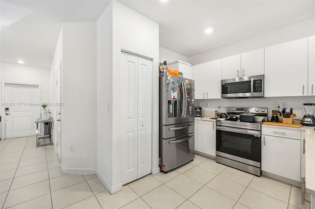 23404 SW 131st Ave, Homestead, FL 33032 - kitchen with stainless steel appliances, light countertops, white cabinetry, light tile patterned floors, and recessed lighting