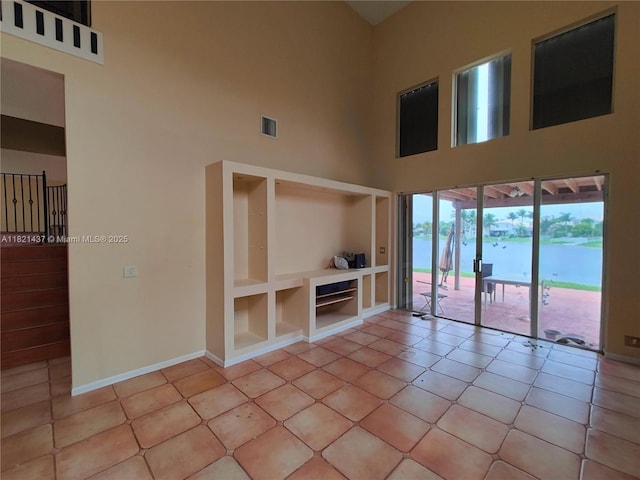 15651 NW 14th Ct, Pembroke Pines, FL 33028 - unfurnished living room featuring a towering ceiling, light tile patterned floors, and built in features