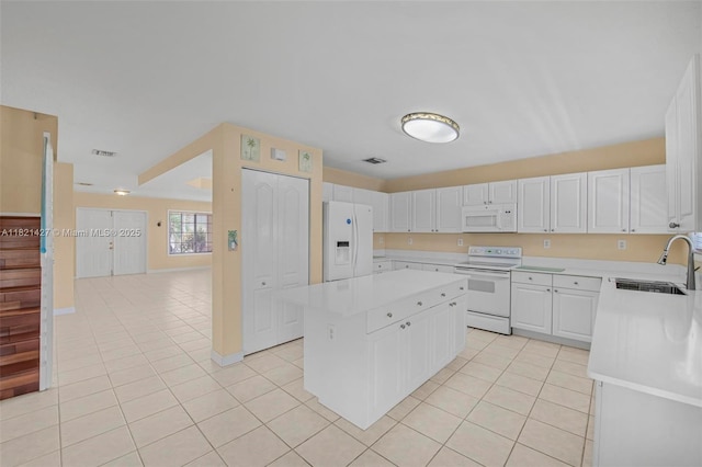 21343 SW 88th Ct, Cutler Bay, FL 33189 - kitchen with white appliances, light tile patterned floors, light countertops, a kitchen island, and white cabinetry