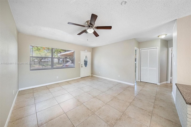6442 Oak St, Hollywood, FL 33024 - empty room with a textured ceiling, a ceiling fan, and light tile patterned floors
