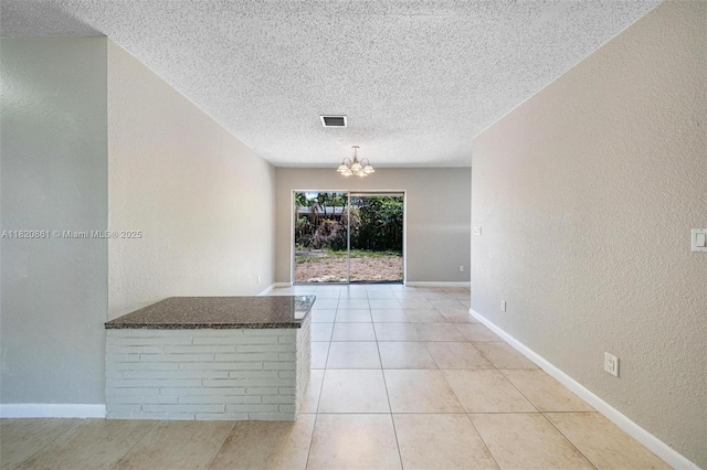 6442 Oak St, Hollywood, FL 33024 - tiled spare room featuring a textured wall, a textured ceiling, and a chandelier